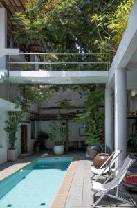 an outdoor swimming pool with two lounge chairs next to a building at La Closerie - Bay of Bengal in Puducherry