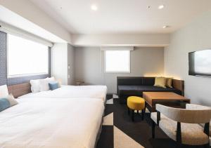 a hotel room with two beds and a couch at Tokyu Stay Sapporo Odori in Sapporo