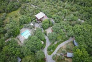 an overhead view of a house with a pool in the forest at Roulottes et Cabanes de Saint Cerice in Vogüé