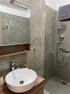 uma casa de banho com um lavatório branco e um chuveiro em Casa Costera 2 lux apt em Kiáton