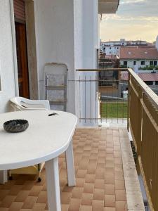 uma mesa branca e uma cadeira numa varanda em Casa alloggio em Scalea