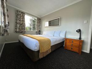 a bedroom with a large bed and a window at Lake Ruataniwha Holiday Park in Twizel
