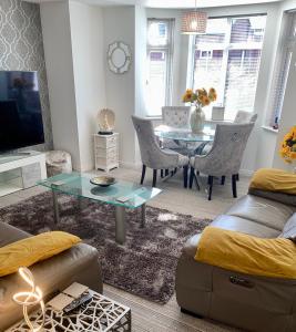 uma sala de estar com uma mesa e uma sala de jantar em Kensington Luxury Apartment on Gated Development in Leafy edge of Chorley Town Centre em Chorley