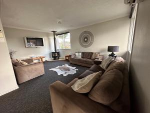 a living room with a brown couch and a table at Lake Ruataniwha Holiday Park in Twizel
