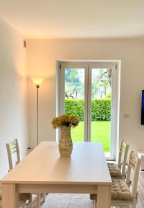 a dining room table with a vase of flowers on it at Guest Martilla Luxury & Garden in Garda