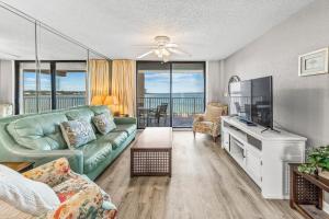 a living room with a couch and a flat screen tv at Compass Point 303 in Gulf Shores +30 photos