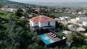 an aerial view of a house with a swimming pool at וילה בין הר לכנרת in Yavneʼel
