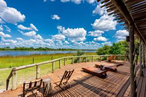 a deck with chairs and a bench and a lake at Semowi Lodge and Campsites in Mirapene