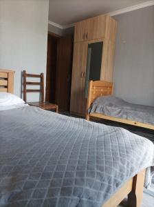 sypialnia z 2 łóżkami, szafką i krzesłami w obiekcie HOMEWOOD w mieście Stepancminda
