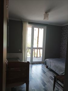 sypialnia z łóżkiem i przesuwnymi szklanymi drzwiami w obiekcie HOMEWOOD w mieście Stepancminda