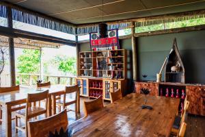 Semowi Lodge and Campsites في Mirapene: غرفة طعام مع طاولة وكراسي خشبية