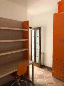 Zimmer mit Regalen, einem Schreibtisch und einer Tür in der Unterkunft Villa Serena in Vibonati