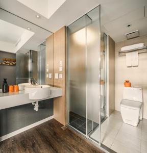 uma casa de banho com um chuveiro, um WC e um lavatório. em Orange Hotel - Ximen, Taipei em Taipei