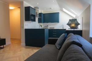 a living room with a couch and a kitchen at Combie Lane Apartment in Oban