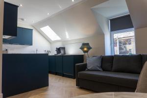 a living room with a couch and a kitchen at Combie Lane Apartment in Oban