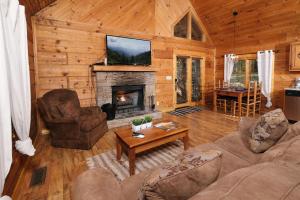 a living room with a fireplace in a log cabin at A Mountain Surprise in Pigeon Forge