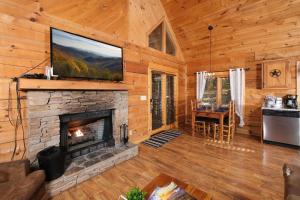 a living room with a fireplace and a flat screen tv at A Mountain Surprise in Pigeon Forge