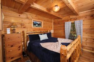 a bedroom with a bed in a log cabin at A Mountain Surprise in Pigeon Forge