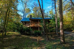 a cabin in the woods with a wrap around deck at A Mountain Surprise in Pigeon Forge