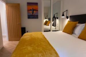 a bedroom with a large white bed with yellow pillows at Combie Lane Apartment in Oban