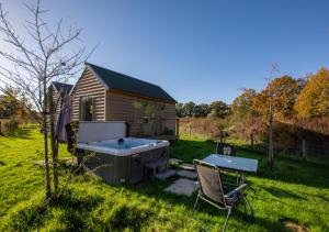 a hot tub and a chair in a yard at The Bolthole in Biddenden