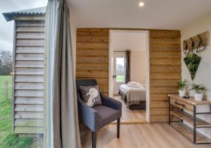 una camera con finestra e sedia e una camera da letto di The Bolthole a Biddenden