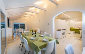 a dining room with a green table and white chairs at Beautiful Home In Arezzo With Outdoor Swimming Pool, Wifi And 6 Bedrooms in Arezzo