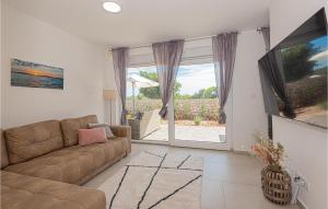 ein Wohnzimmer mit einem Sofa und einer Glasschiebetür in der Unterkunft Pet Friendly Home In Sibenik With Heated Swimming Pool in Šibenik