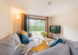 a living room with a couch and a tv at The Boathouse in Biddenden
