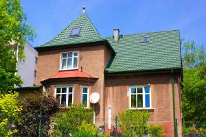 a large brick house with a green roof at Domek na Wzgórzu in Cieszyn