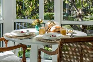 a table with food and drinks on a porch with windows at Hideaway Studio in Dunsborough