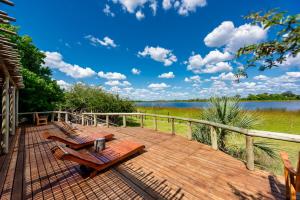 MirapeneSemowi Lodge and Campsites的湖景甲板配有长椅