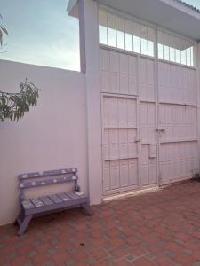 ein Gebäude mit zwei Garagentüren und einer Bank in der Unterkunft La fam in Huajuapan de León