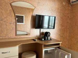 a room with a desk with a tv on a wall at Guest House Val and Kate in Sveti Vlas