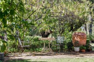 una mesa al aire libre y sillas bajo un árbol en Hideaway Studio en Dunsborough