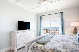 een slaapkamer met een bed, een tv en een raam bij Gray Dolphin III in North Topsail Beach