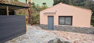 Casa con puerta morada y entrada de piedra en Casa Del Torrente en Porto Ota