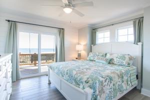 een slaapkamer met een bed en uitzicht op de oceaan bij Gray Dolphin III in North Topsail Beach