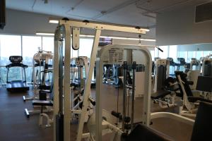 a gym with lots of treadmills and machines at Stunning 12th Floor Studio In The Heart Of Grove in Miami