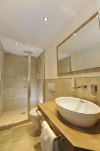 a bathroom with a large white sink and a shower at Landidyll Hotel Haus Hochstein in Wenholthausen