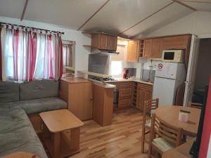a small kitchen with a couch and a table and a kitchen with a tablektop at Sun Sea camping le Bosc in Saint-Cyprien