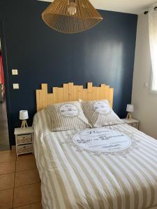 uma cama num quarto com uma parede azul em bienvenue chez nous em Badens