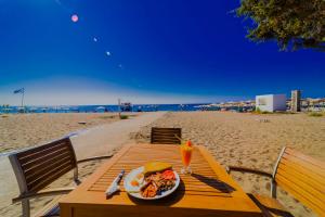 a plate of food on a table on the beach at Amaryllis front beach hotel in Lartos