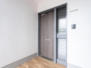 a door in a room with a wooden floor at Reality Hakata 2 in Fukuoka
