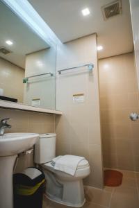a bathroom with a toilet and a sink and a mirror at Manila Grand Opera Hotel in Manila