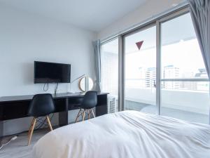 a bedroom with a bed and a desk with a television at Reality Hakata 2 in Fukuoka