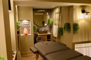 a massage room with a mirror and a massage table at love room gold - les delices rooms in Angers +9 photos