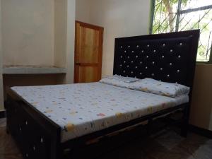 Boma la NgombeにあるAirb&b Homestayのベッドフレーム付きの客室のベッド1台分です。