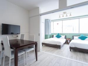 a bedroom with a table and a bed and a tv at Reality Hakata 2 in Fukuoka