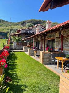 una casa con prato, tavolo e sedie di Theano Apartments a Sárti